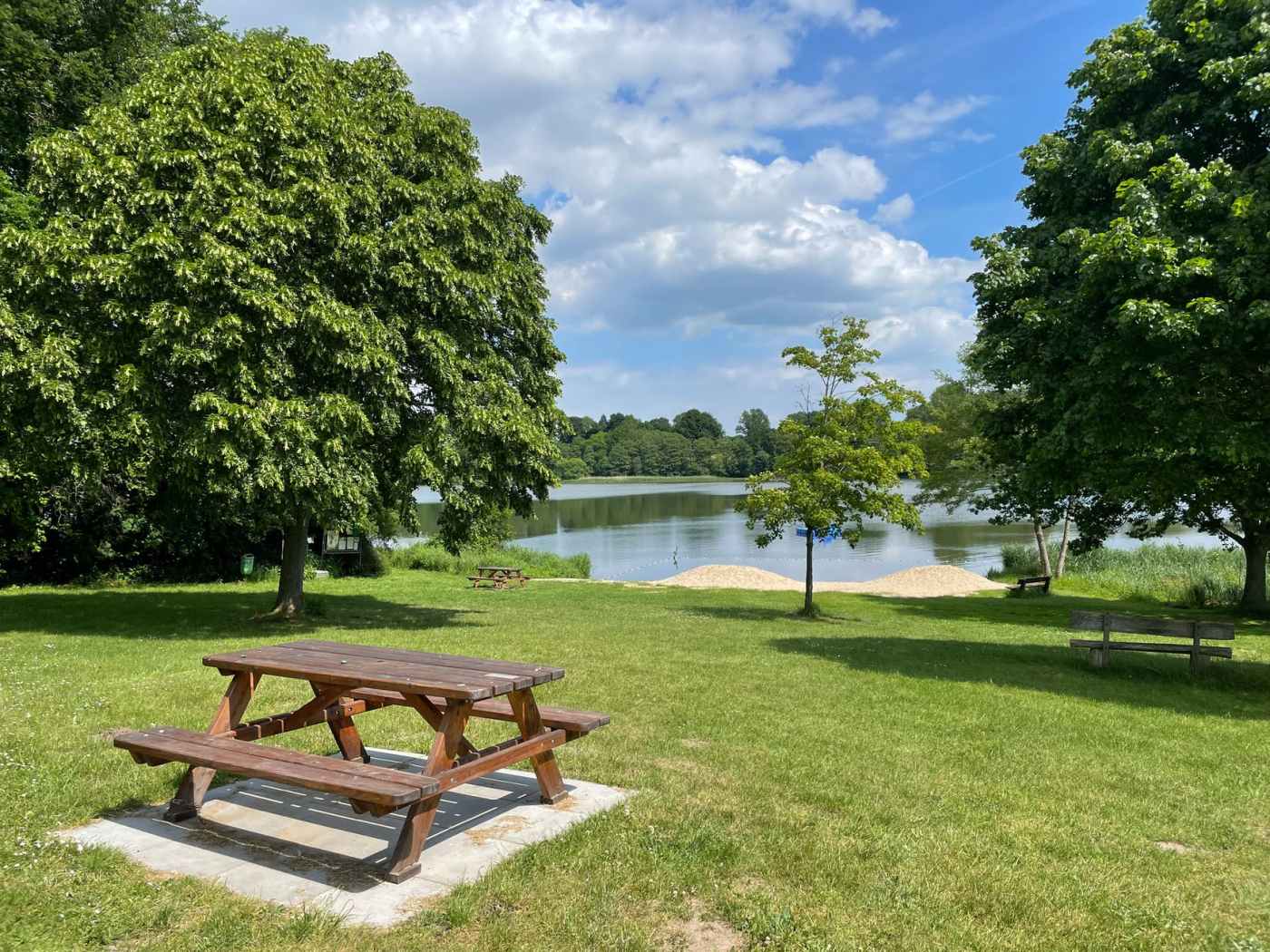 photo of a brown picnic table near a lake